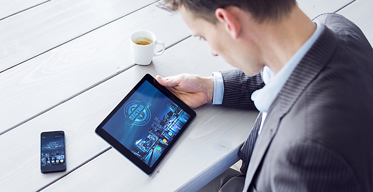 Man sitting at a table with a tablet and a cup of coffee