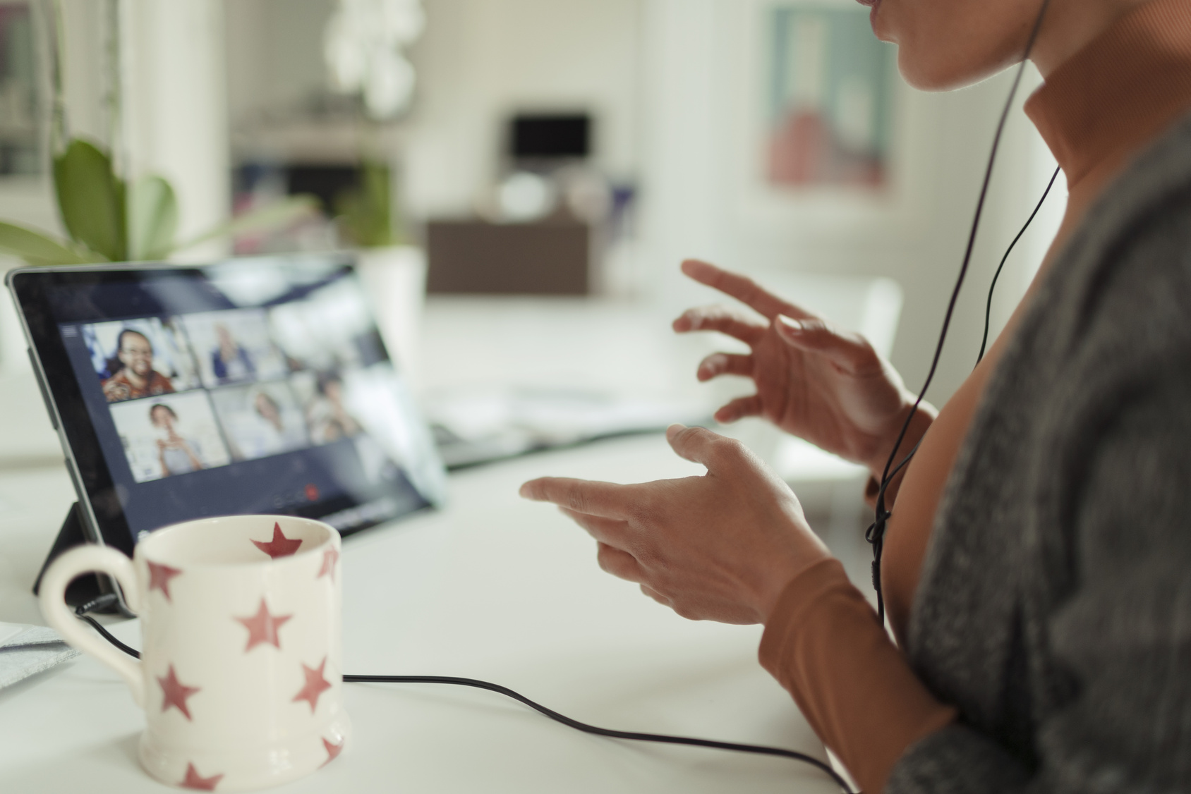 Woman video conferencing with colleagues with tablet at home