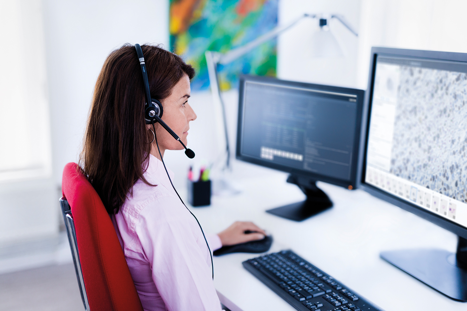 Female pathologist with headset working with Sectra Digital Pathology Solution