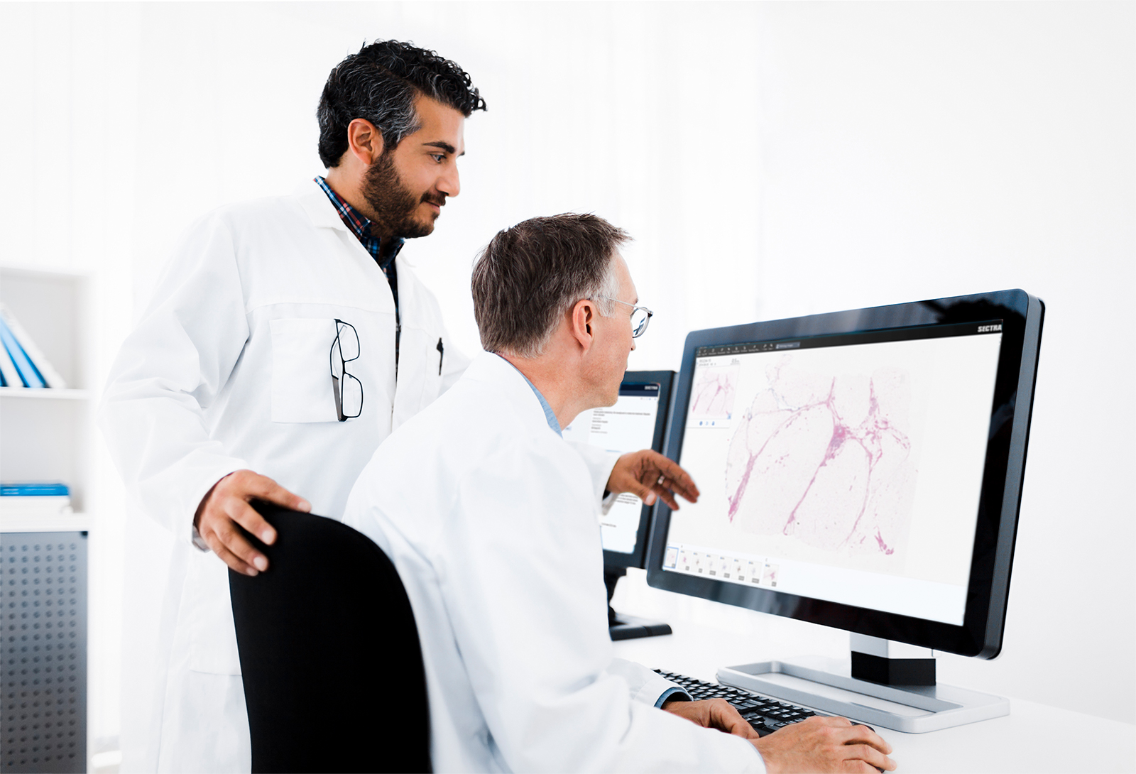 Two male pathologists looking at a digital pathology image in the Sectra Pathology PACS