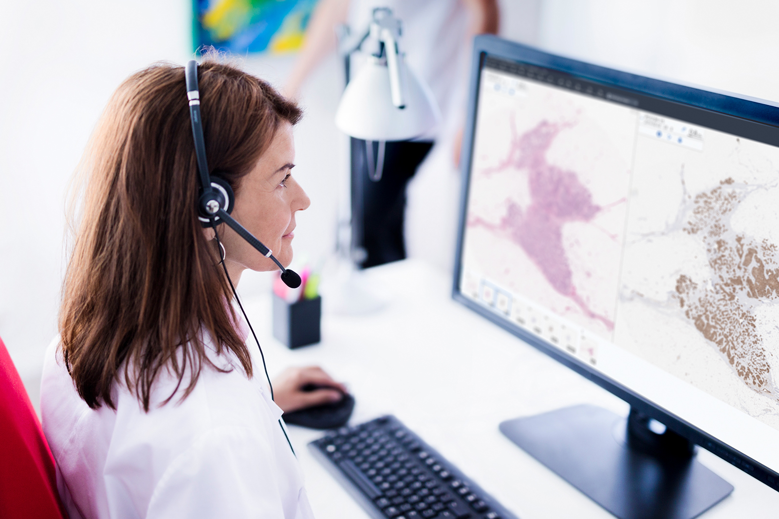 Female pathologist with headset working with Sectra Digital Pathology Solution