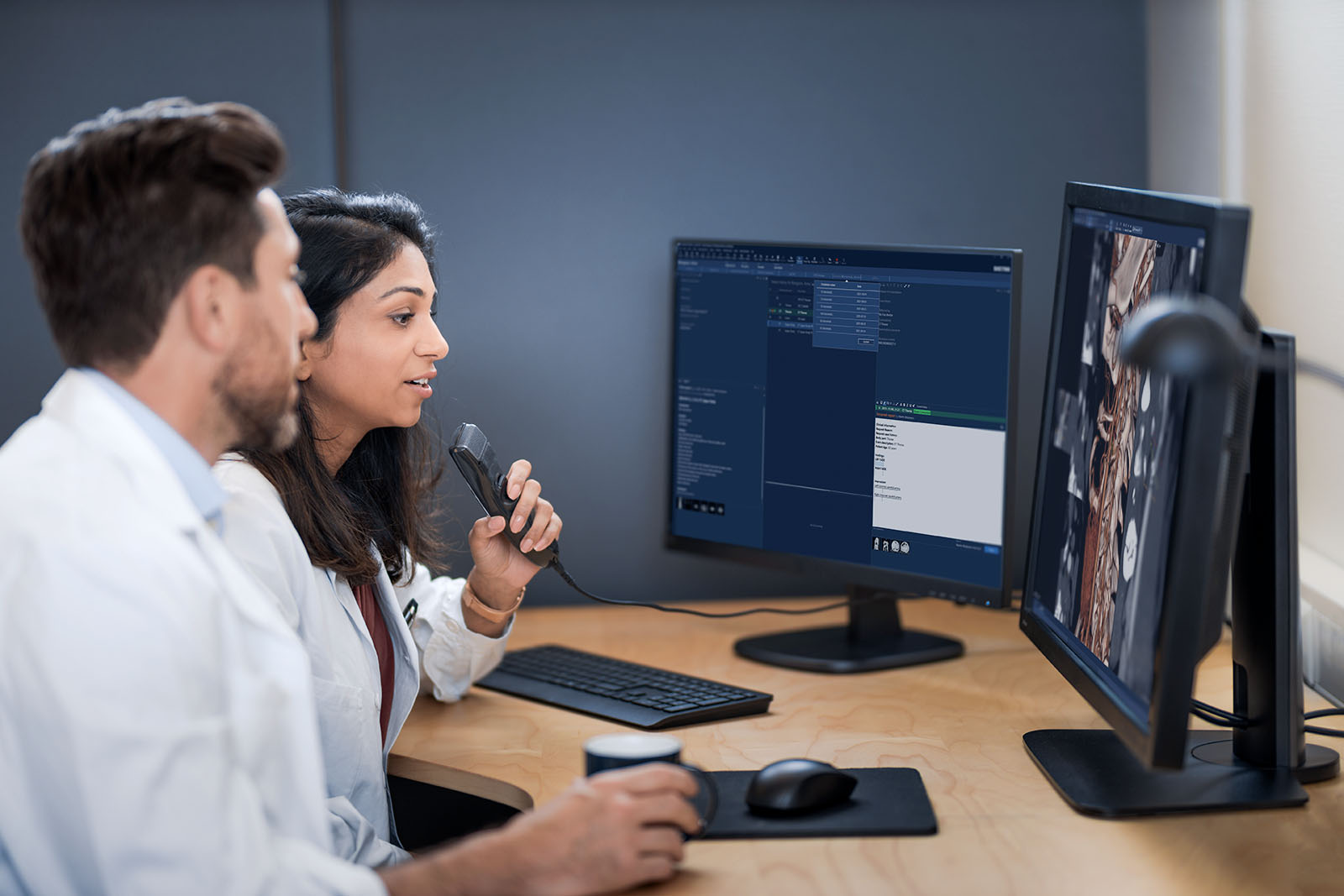 Two radiologists in front of a monitor with speech recognition