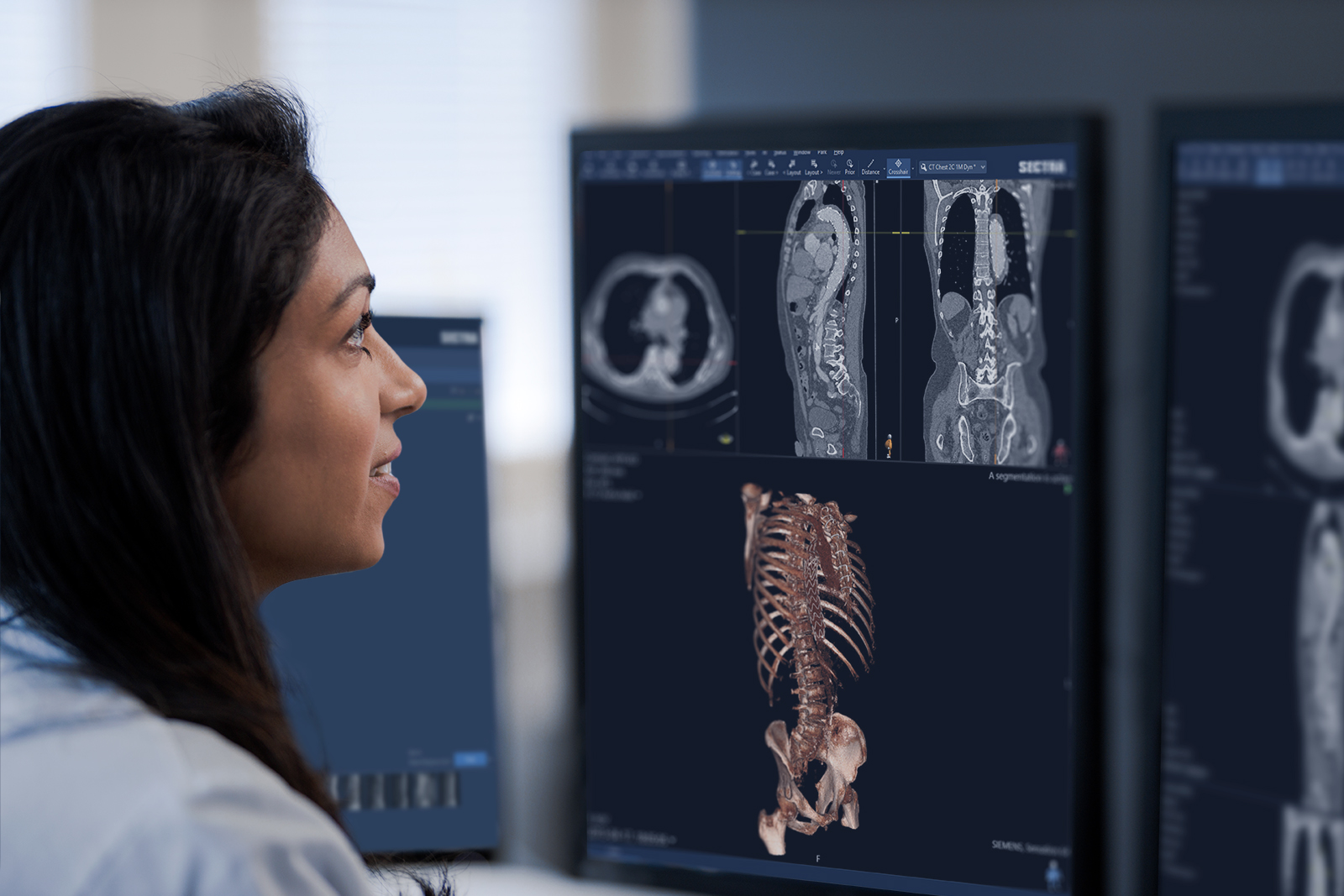 Female radiologist studying a radiology case in front of a monitor