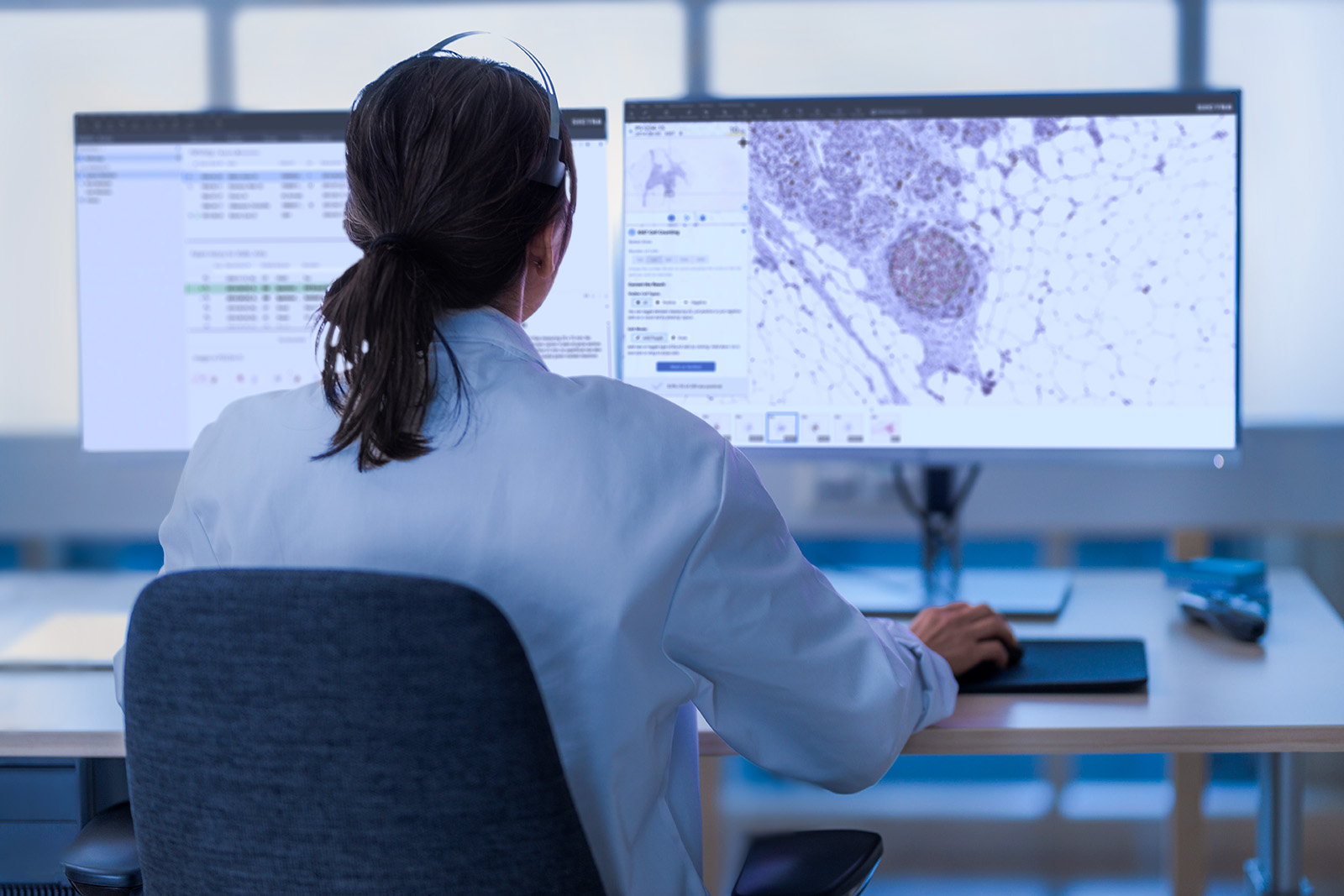 Female pathologist in front of a monitor with headset