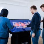 Three students interacting with medical image on the Sectra table